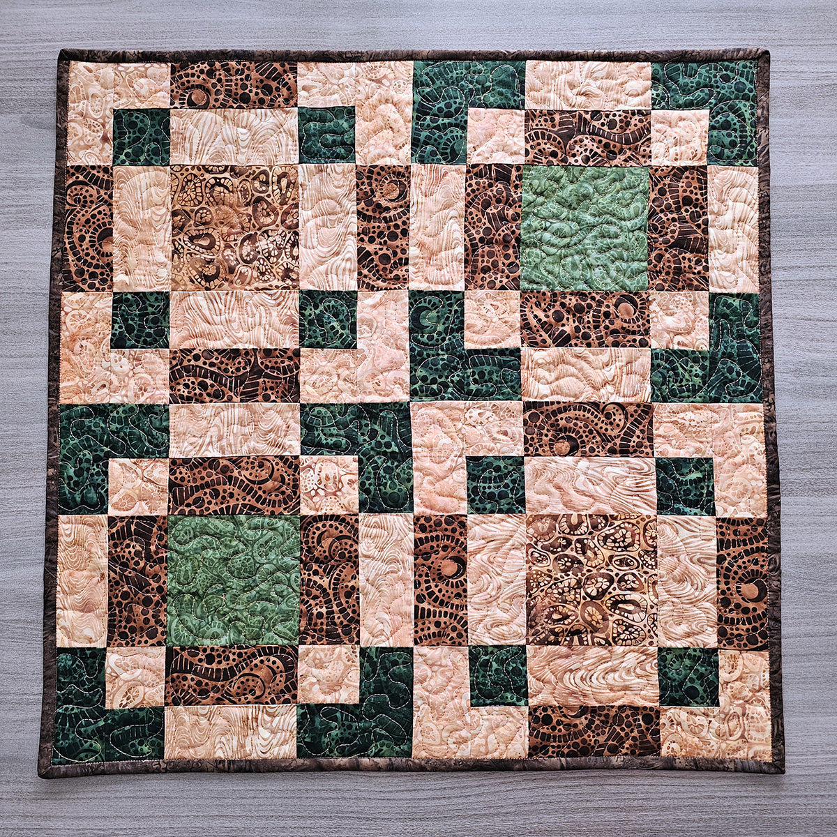 A table topper made from a type of disappearing 9 patch quilt block