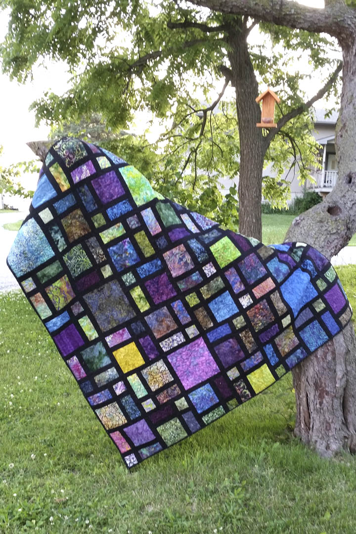 Scattered quilt pattern is fast and easy to make using black at the sashing for the blocks