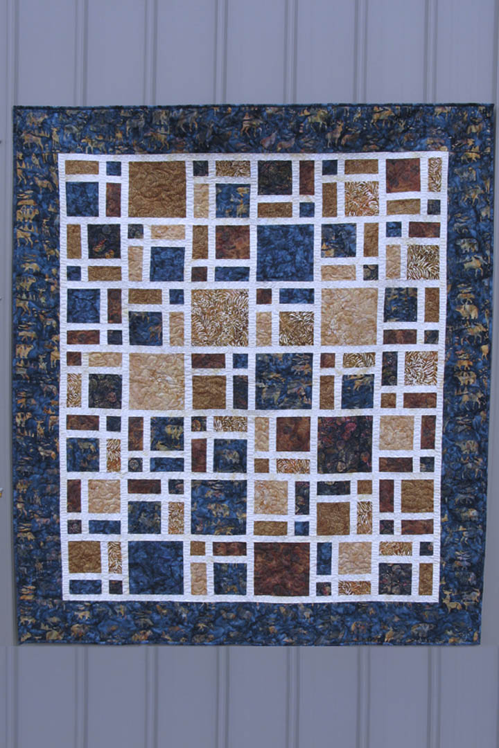 Scattered quilt pattern is fast and easy to make using creat at the sashing and bold browns and navy batiks for the blocks