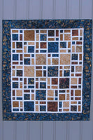 Scattered quilt pattern is fast and easy to make using creat at the sashing and bold browns and navy batiks for the blocks